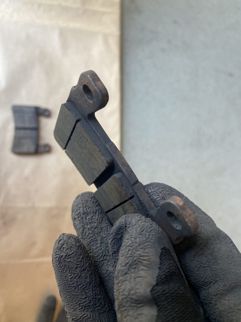 Photo of a brake pad being held between fingers
