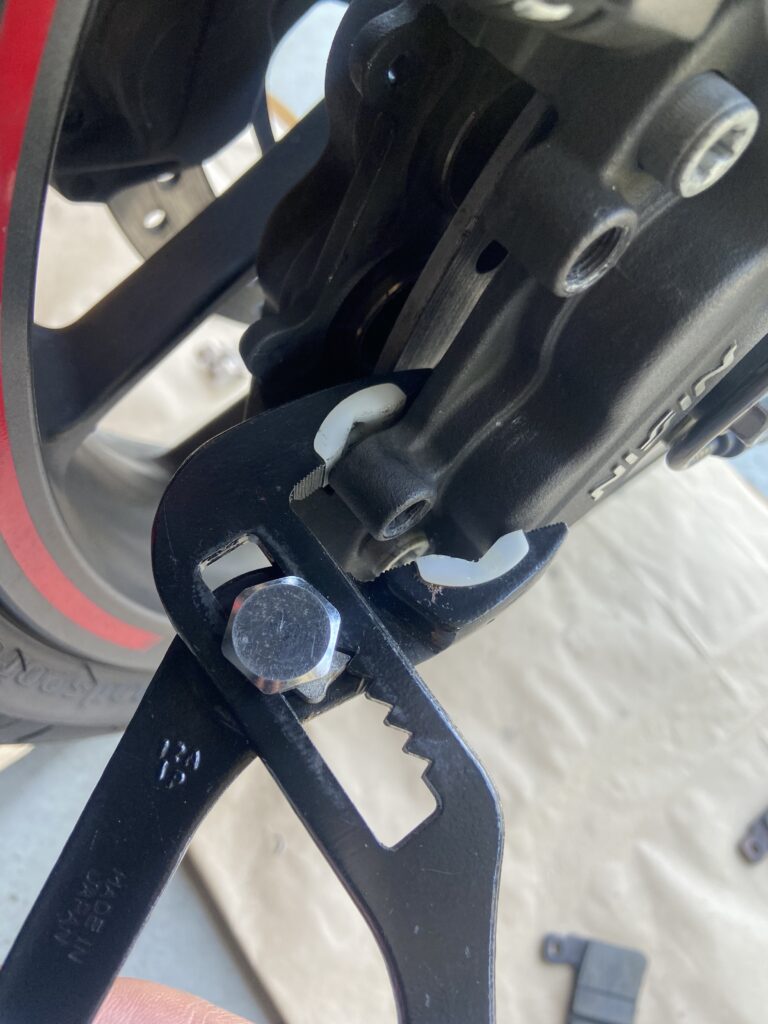 Photo showing a piston of the brake caliper being compressed with water pump pliers