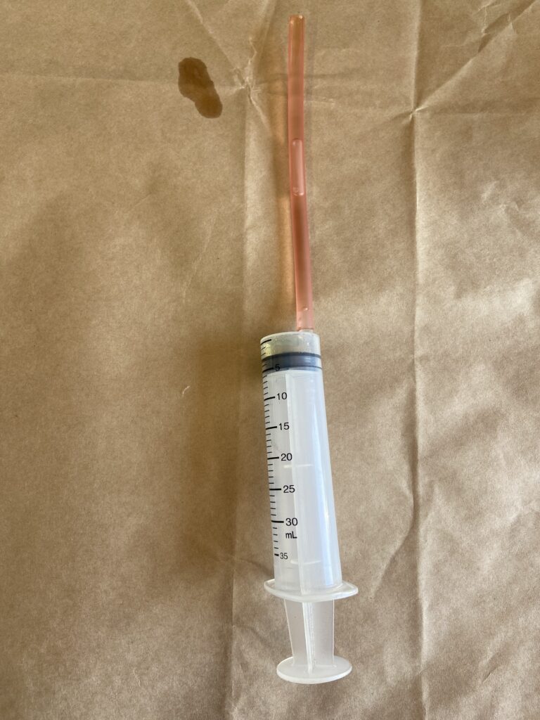 Rubber hose syringe used to extract brake fluid